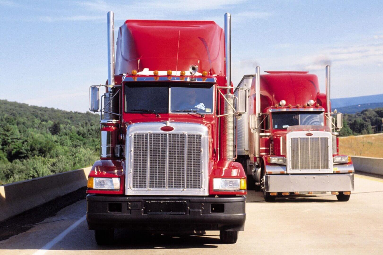 Two Red Trucks in a Row Next to Each Other
